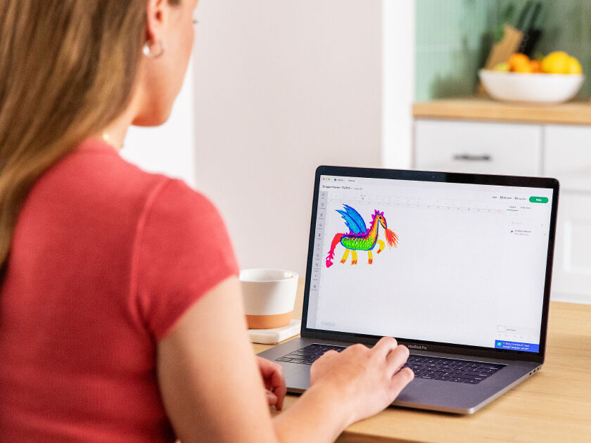 Woman's hand holding a smart phone with a personalized project template pulled up using Cricut's Design Space app