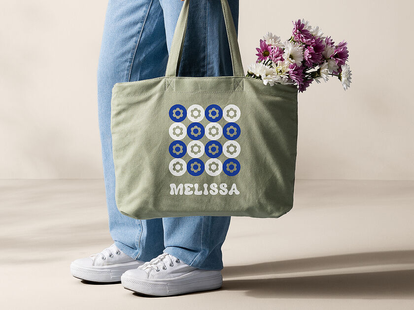 Woman's hand holding a smart phone with a personalized project template pulled up using Cricut's Design Space app