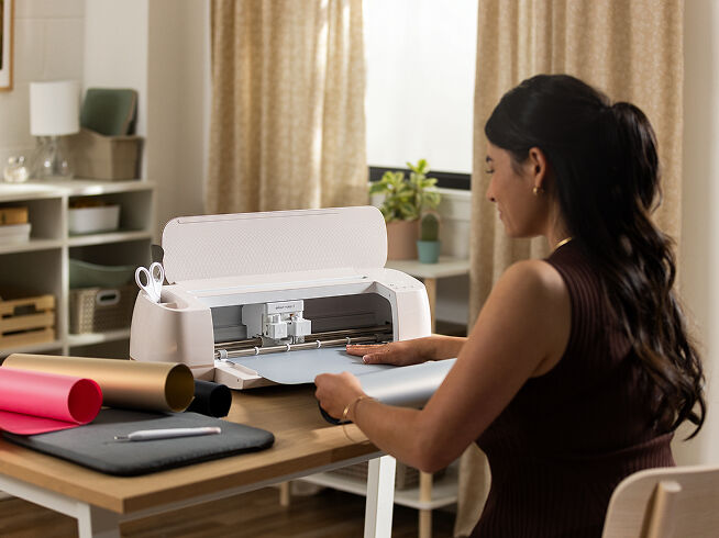 Woman's hand holding a smart phone with a personalized project template pulled up using Cricut's Design Space app
